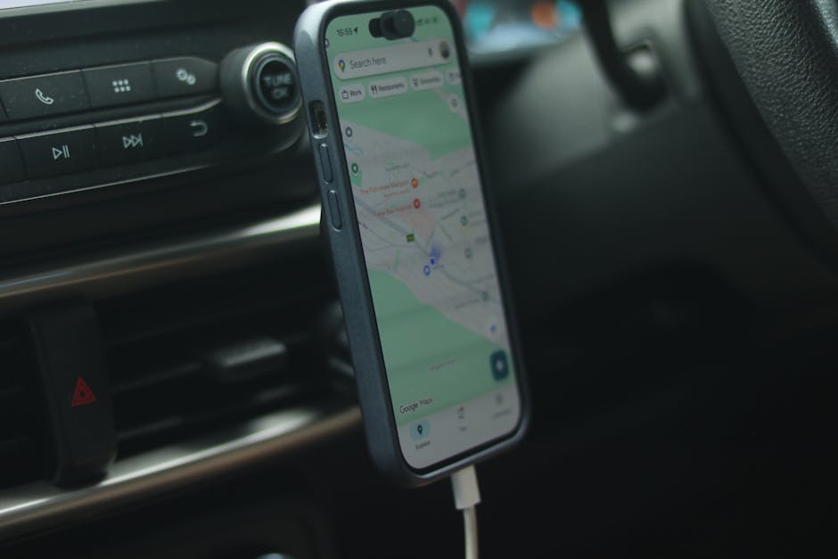 A smartphone with a map app displayed inside a car, showing modern navigation.