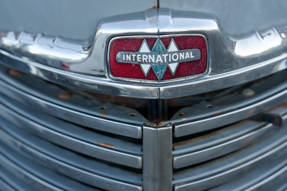 Close-up of a vintage International truck grille showcasing the iconic logo and chrome detailing.