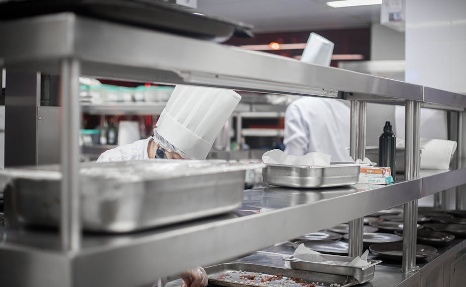 Chefs working diligently in a modern stainless steel kitchen, preparing delicious dishes.