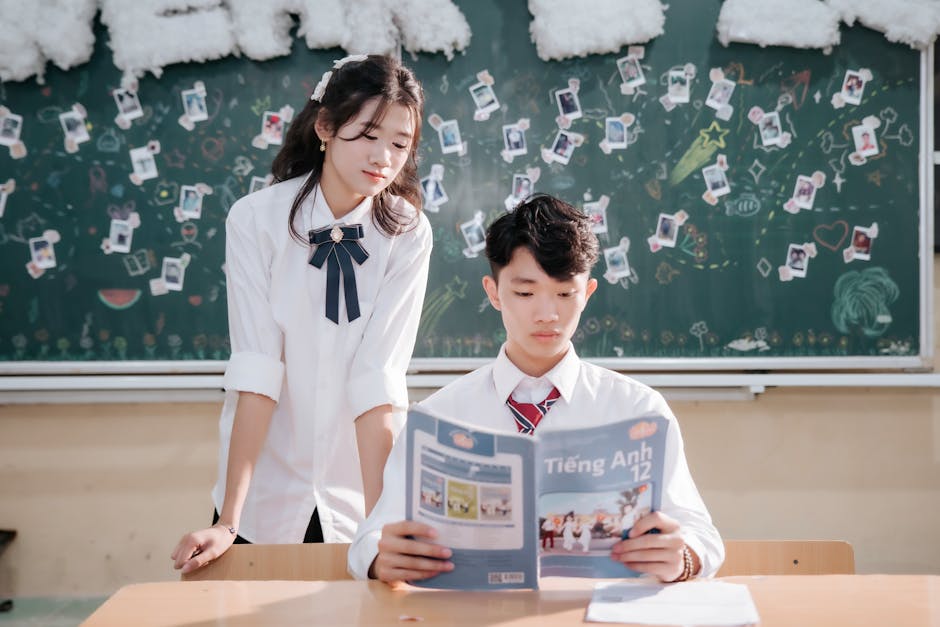 Two students engage with reading material in a lively classroom setting.