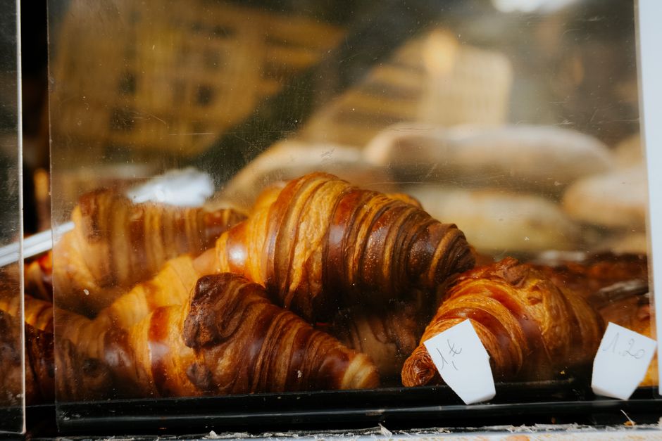 Close-up of freshly baked croissants in a clear display case, perfect for food photography.
