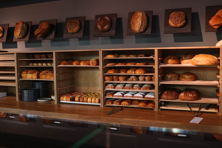 A display of freshly baked bread and pastries in a cozy artisan bakery interior.