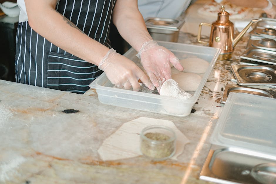 Close-up of hands preparing bread dough in a kitchen setting with a copper kettle.