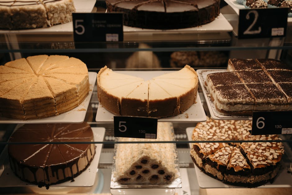 A mouthwatering assortment of cakes and pastries beautifully arranged in a bakery display.