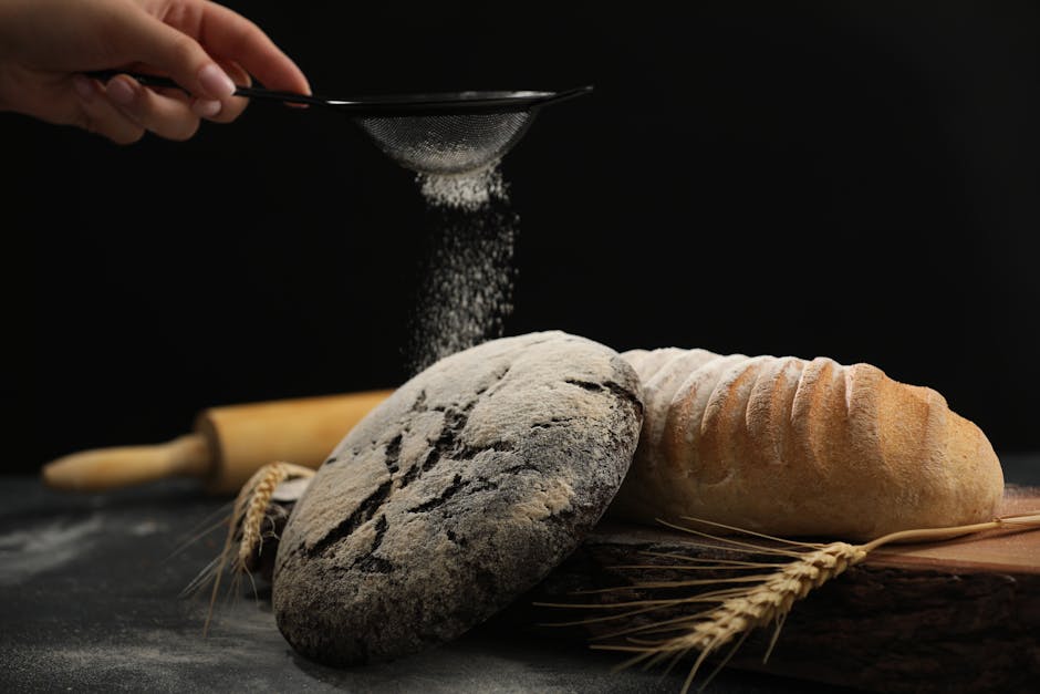 Close-up of artisan bread with flour being sifted over it, evoking a warm and rustic feel.