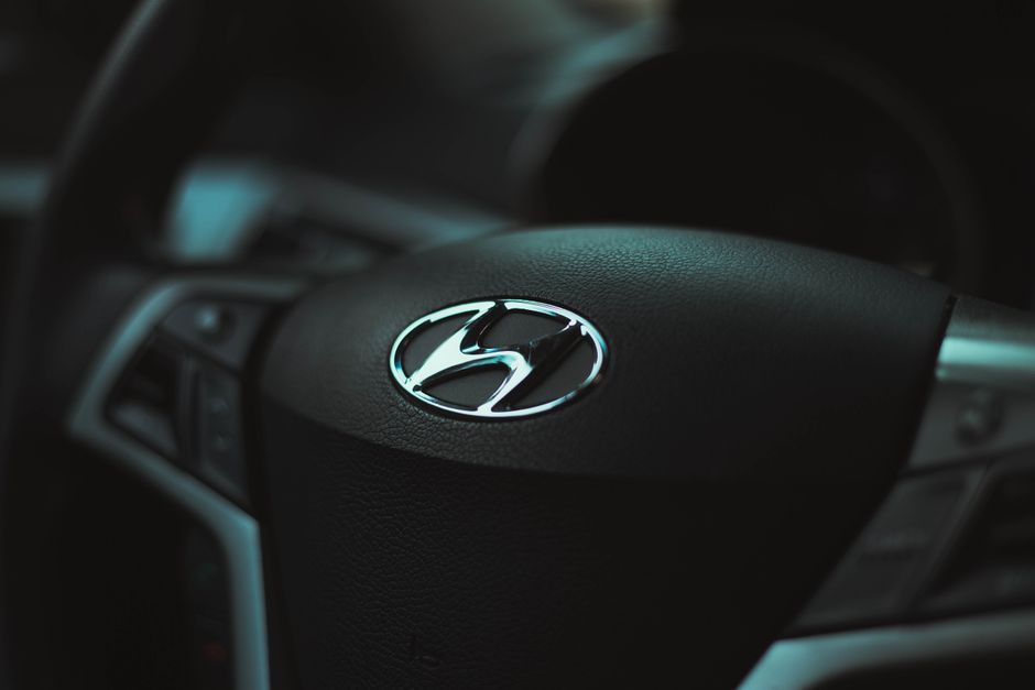 Detailed view of a car steering wheel featuring a prominent logo, highlighting the vehicle's interior design.