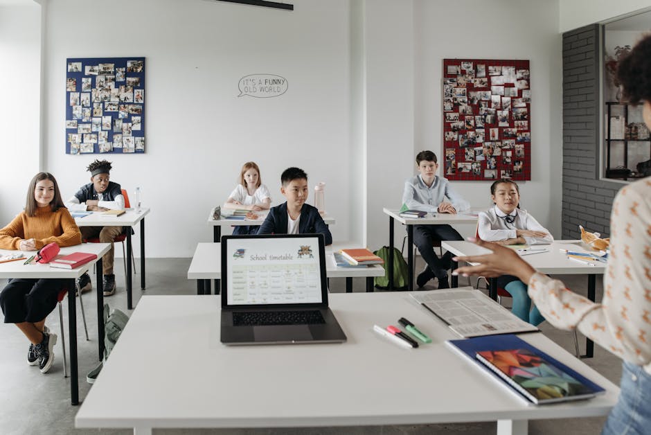 Students in a modern classroom learn with technology under teacher's guidance.
