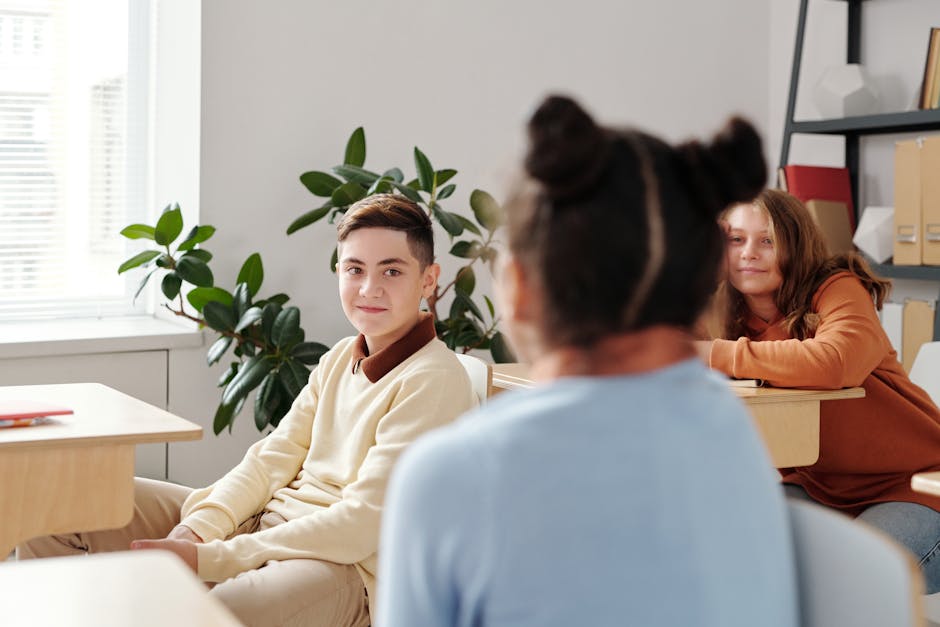 Diverse group of teenagers interacting in a bright classroom setting with natural lighting.