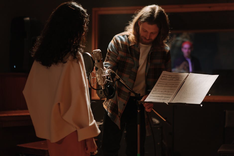Musicians collaborate in a recording studio with a condenser microphone and music stand.